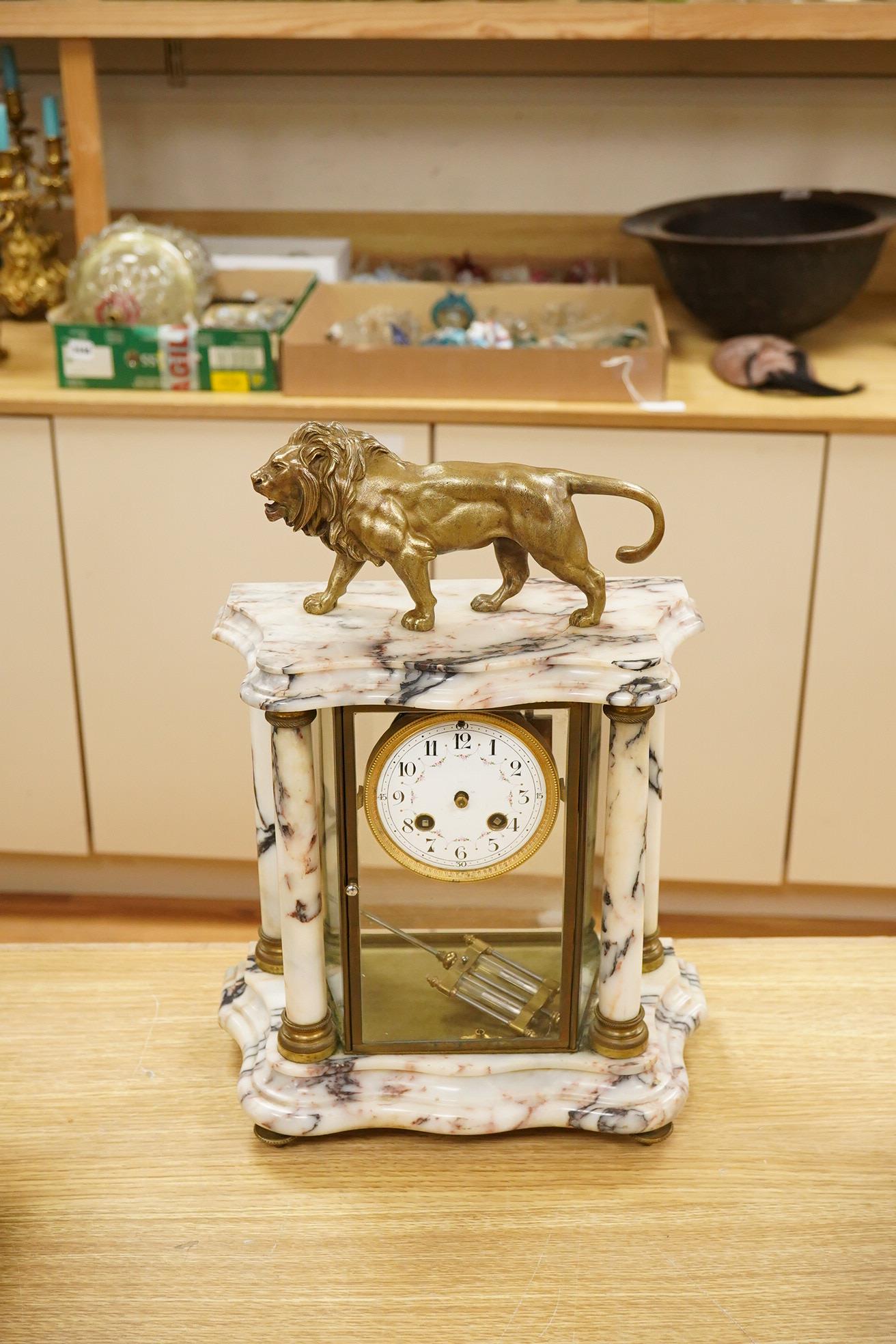 An early 20th century marble mantel clock with lion surmount, with pendulum, 39cm high